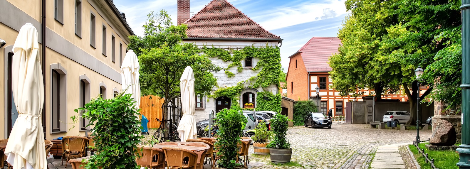 Gemütlicher Innenhof mit Tischen, Stühlen und Pflanzen.