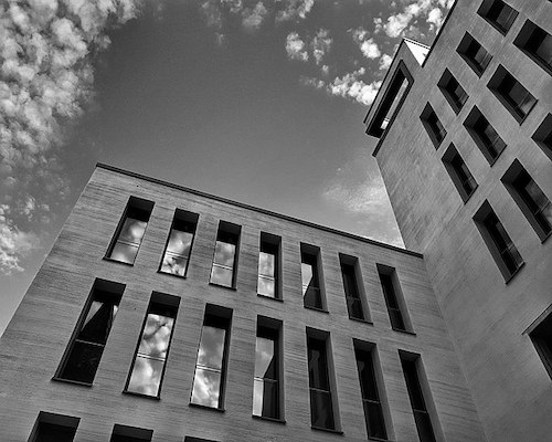 Moderne Gebäude mit Wolkenreflexionen in Schwarz-Weiß.